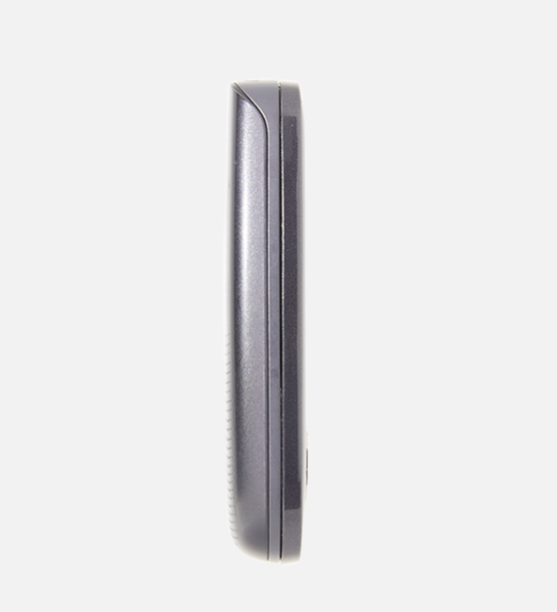 A close-up side profile of a dark gray or black electronic device, possibly a speaker or receiver, on a solid light gray background.