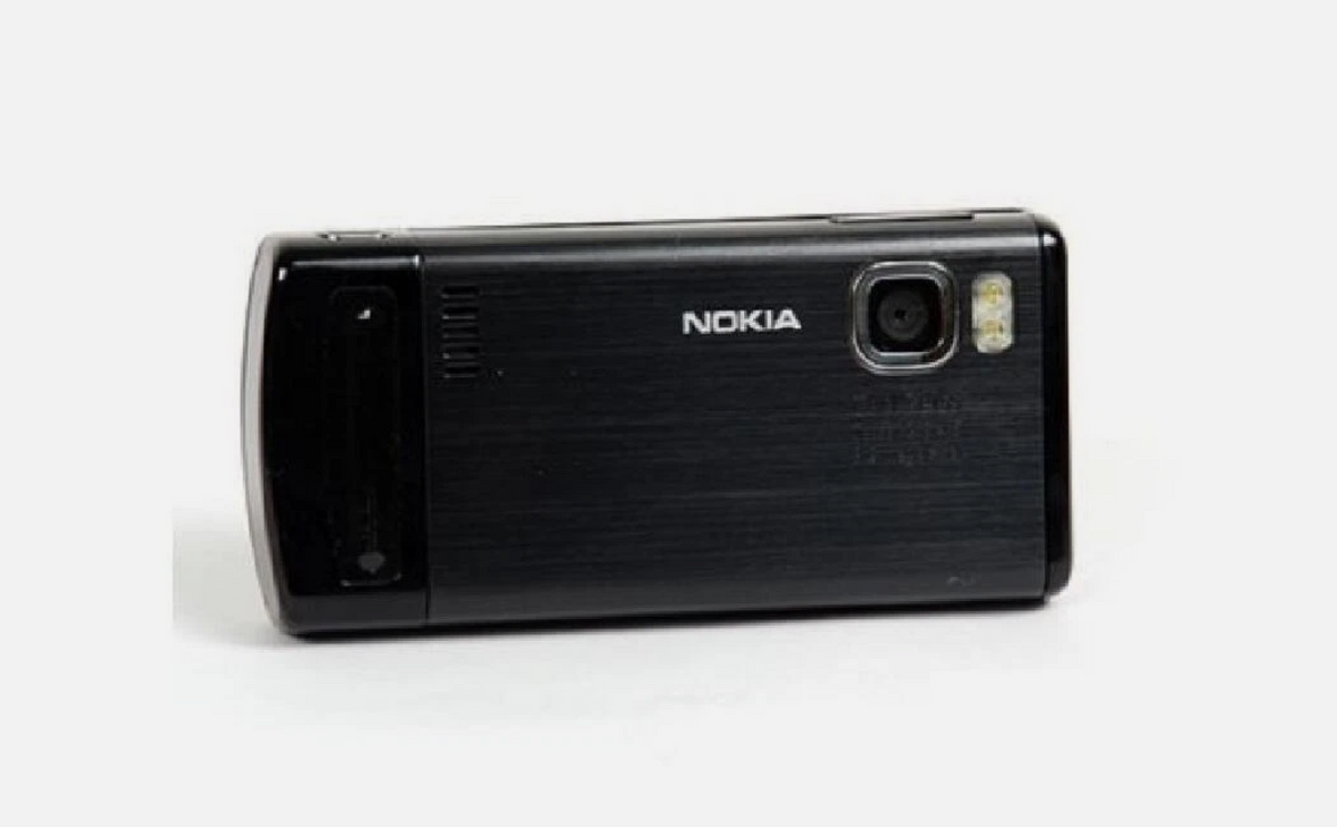 A black Nokia flip phone with a brushed metal back cover, shown from the rear on a plain white background.